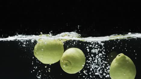 video of three limes underwater with copy space over black background