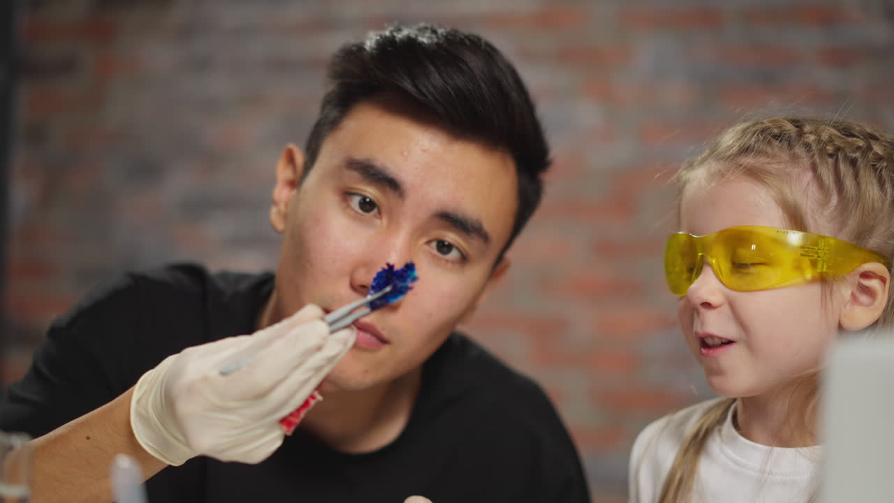 선생님은 작은 학생과 함께 리크무스 시험의 결과를 배 ⁇ 니다.