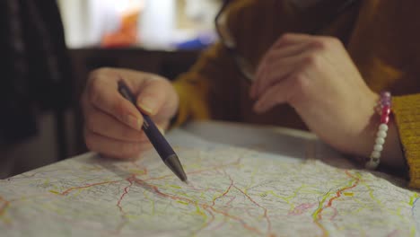 Detalle-De-La-Mano-De-Un-Hombre-Sobre-Un-Mapa,-Buscando-Nuevos-Destinos-Y-Un-Camino