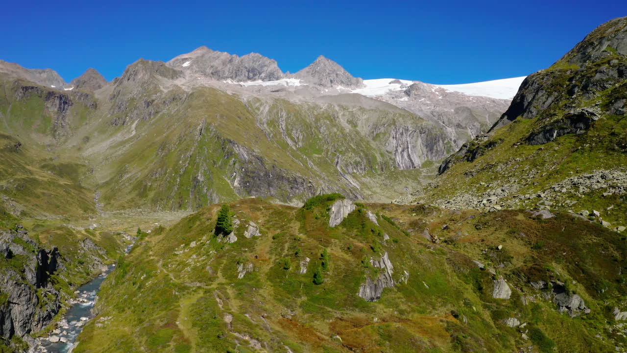 vista aérea de los alpes de zillertal orbitando valles alpinos escarpados y cordillera nevada