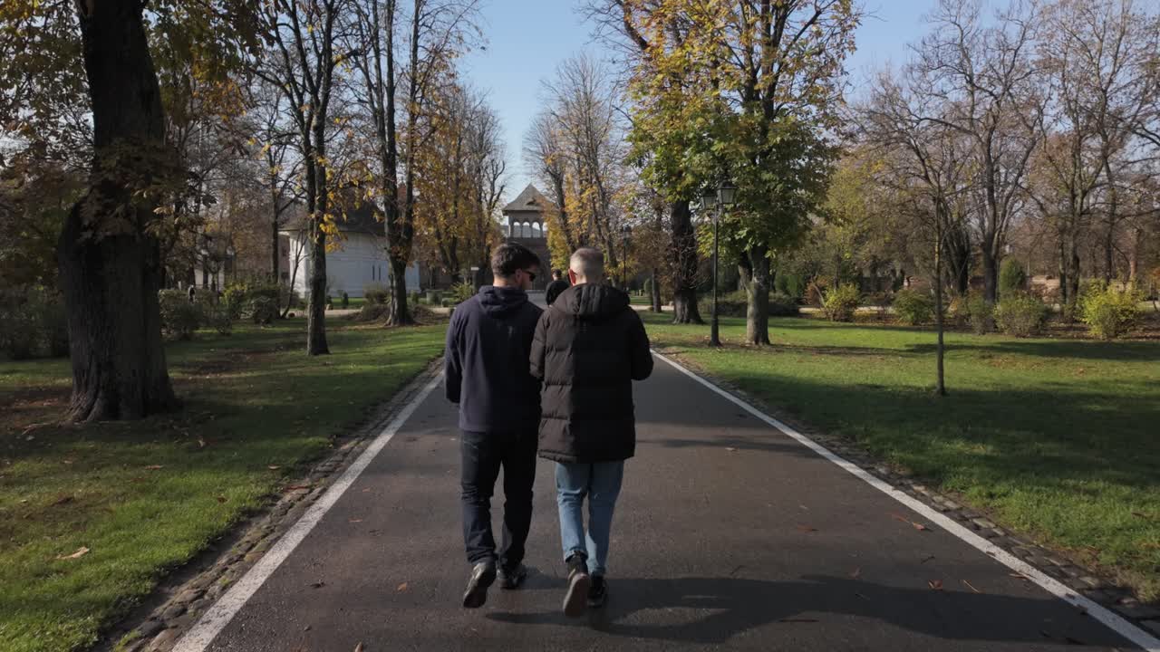 Visitors strolling on sunny garden path at Mogosoaia Palace Romania