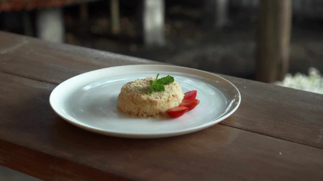 Piccola torta millefoglie con fragole sopra, su un piatto bianco