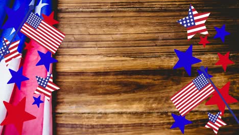 Animation-of-stars-and-stripes-over-american-flag-on-wooden-table