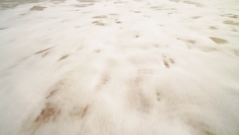 ocean wave on sandy beach.