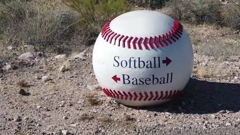 a large baseball is used as a directional sign for baseball and softball fields, papago park, papago sports complex, phoenix, arizona