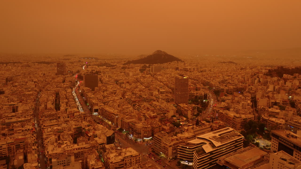 Thick orange dust from Sahara blankets Athens city skyline in low visibility, aerial
