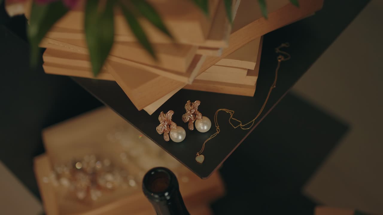Primo piano di gioielli da sposa con orecchini di perle e collana delicata su libri di legno in luce calda