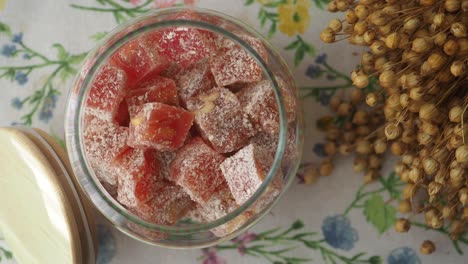 turkish delight in a glass jar on a floral tablecloth
