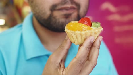 man eating a fruit tart