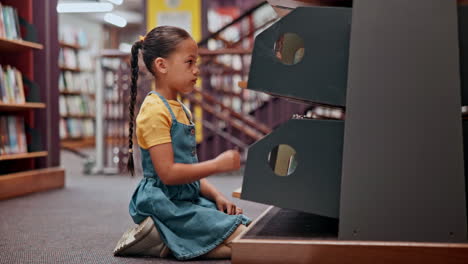 child looking at books in a library