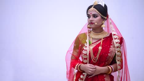 sad and unhappy indian bengali bride against a white wall