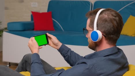 el hombre está usando un teléfono inteligente con un modelo de pantalla verde