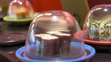 Close-up-shot-of-fresh-sushi-on-conveyor-belt-in-noble-sushi-restaurant