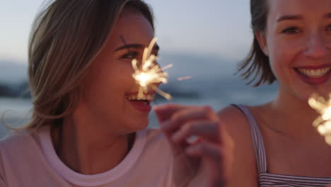 happy friends light sparklers on beach having fun new years eve party