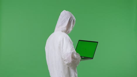 back view of asian male scientist use green screen laptop while standing on green screen background