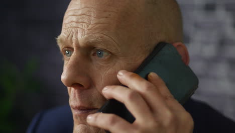 worried mature businessman close up listening on cellphone