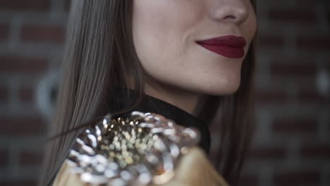 close-up of a woman's shoulder with decorative chain and tassels