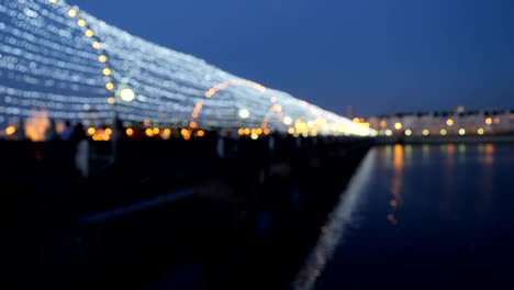 el fondo oscuro borroso de la gente del puente por la noche.