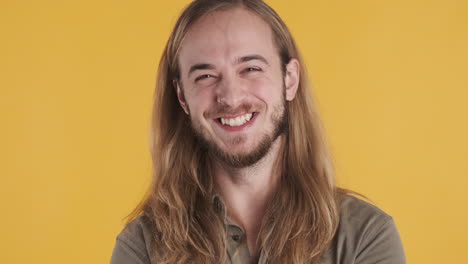 un joven caucásico sonriendo a la cámara.