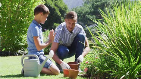 Kaukasischer-Vater-Und-Sohn-Arbeiten-An-Einem-Strahlend-Sonnigen-Tag-Gemeinsam-Im-Garten