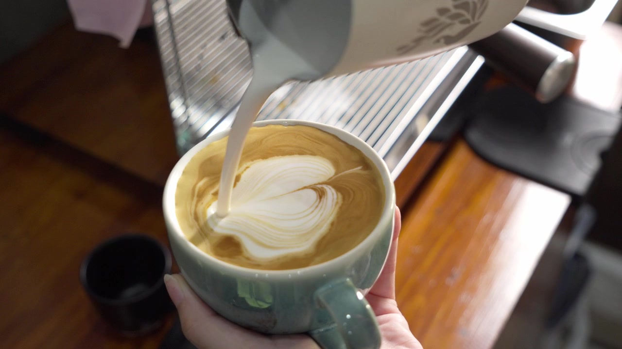 Versamento di latte in tazza da espresso, primo piano di Latte Art