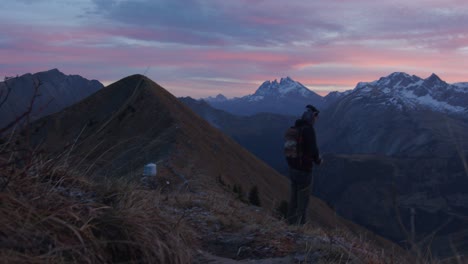 a hiker is looking through his binoculars at dusk