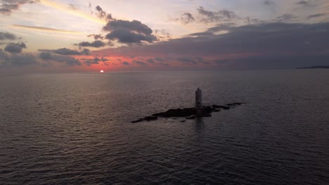 Increíble-Vista-De-La-Impresionante-Puesta-De-Sol-Con-Faro-En-Alta-Mar-En-Calasetta,-Antena