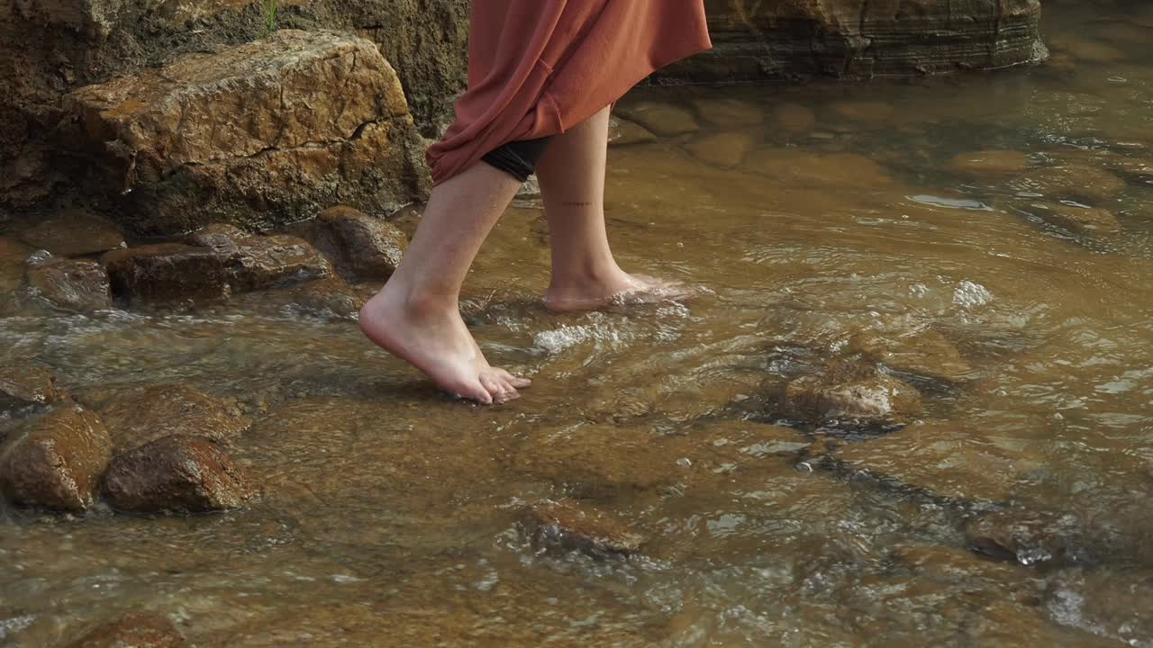 Woman wading in a shallow stream