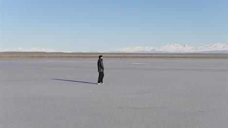 lonely man wandering across endless white salt desert, emotional solitude concept