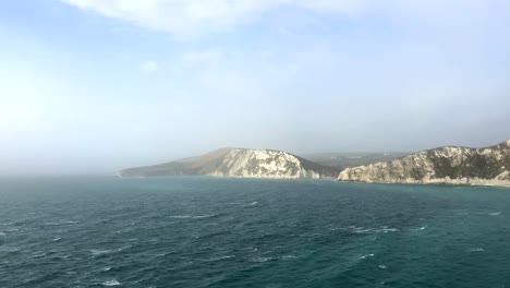 Panoramic-aerial-view-of-chalk-cliffs-and-the-ocean-on-the-coast-of-Dorset,-England