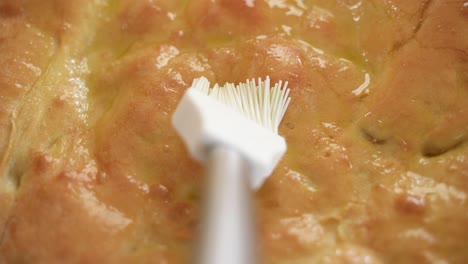 cubra la superficie del pan recién horneado con aceite, manchando con un cepillo blanco, punto de vista