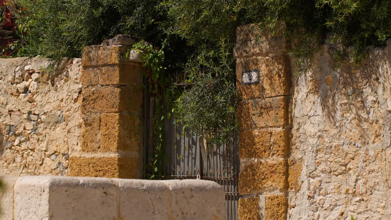 Old stone gateway in Scopello city center, Sicily on a sunny day