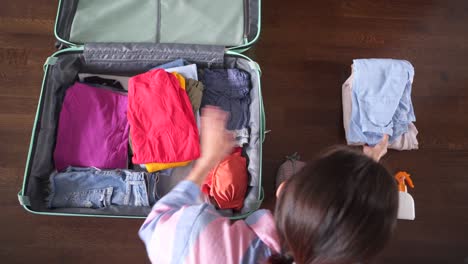 woman finishes packing her travel suitcase