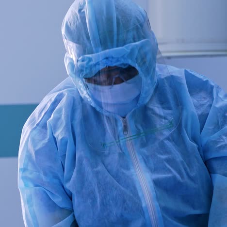 doctor in safety suit in the hospital. medical worker in blue protective uniform with respirator on face working in clinic. coronavirus pandemic.