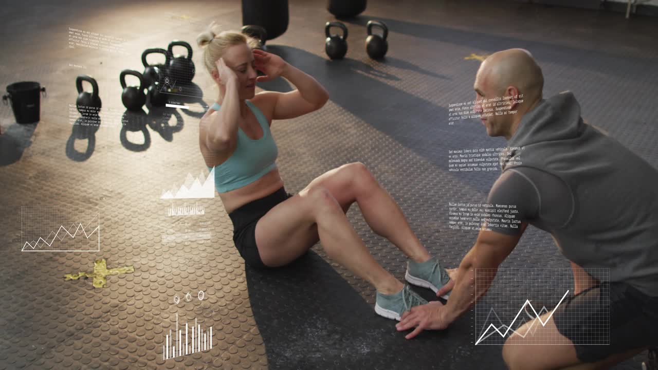 Woman doing sit-ups on mat, trainer holding feet starting set, charts growing showing core strength