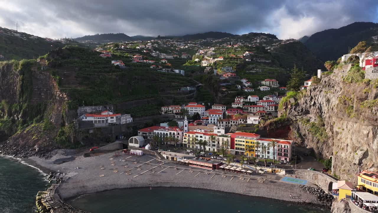 Veduta panoramica di Ponta do Sol, località marittima sull'isola di Madeira con spiaggia di ciottoli, dolly aereo