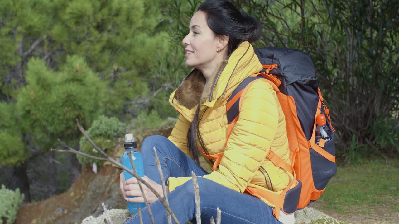 joven mochilero haciendo una pausa para el agua