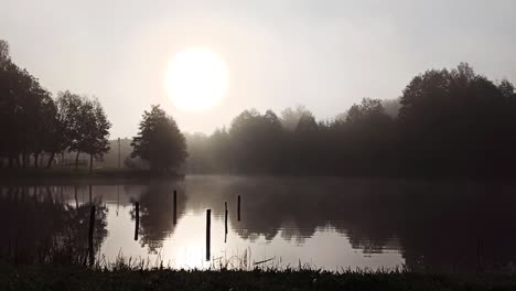 Lago-En-La-Luz-Etérea-De-La-Madrugada-Con-Nubes-Bajas-Y-Brumosas