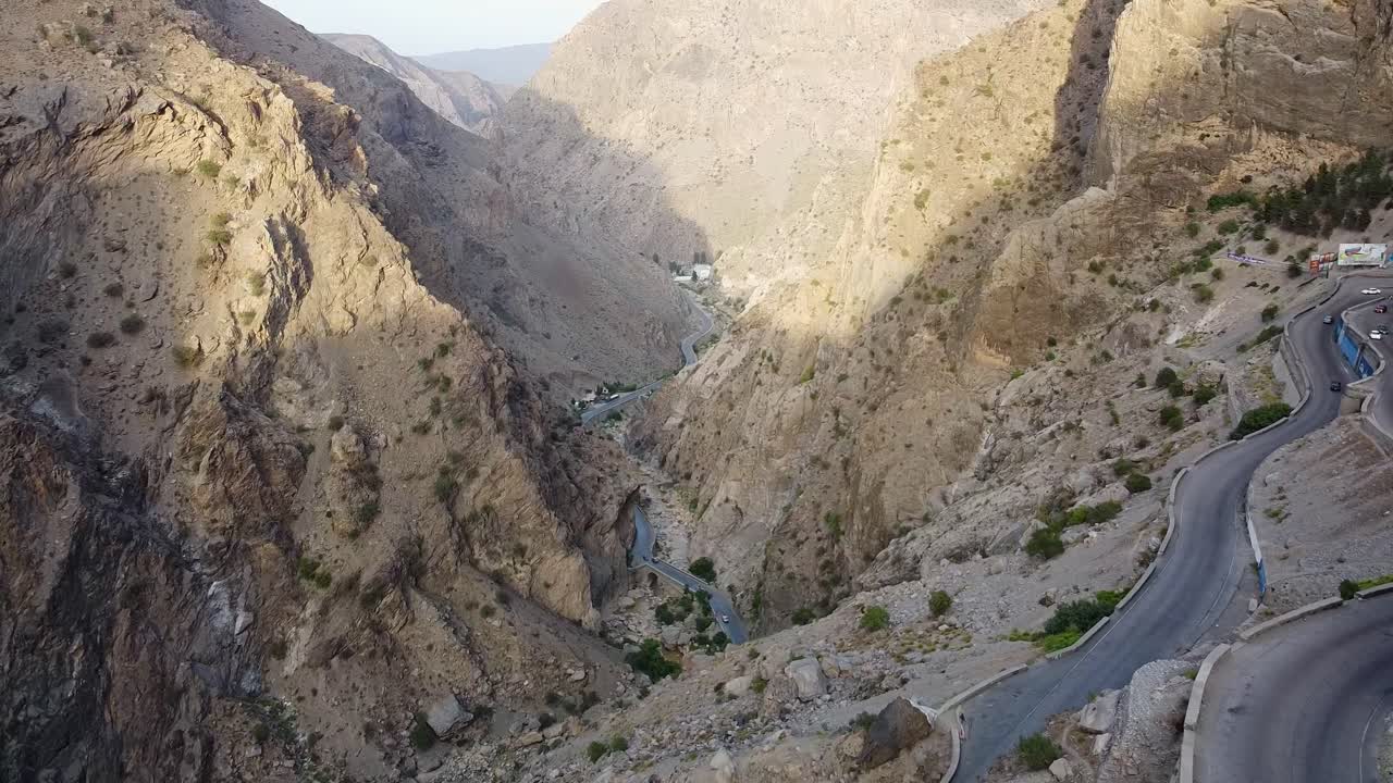 Luftfoto med drone af en flod, der snor sig gennem en frodig og robust bjergdal i Kabul, Afghanistan