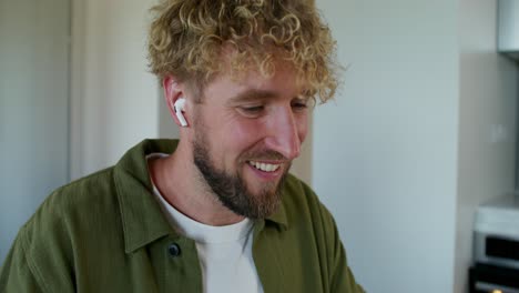 man wearing earbuds in kitchen