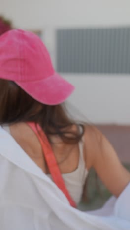 young woman wearing a pink hat and white shirt