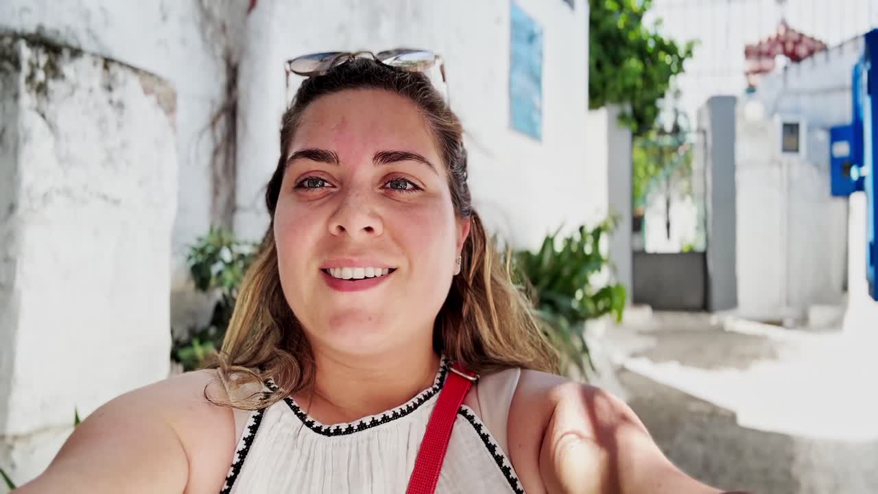 Donna vlogger che guarda in alto mentre filma ad Atene