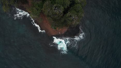 top view - sea waves hitting and splashing on the rocky cliff  in costa rica coast.-  aerial shot