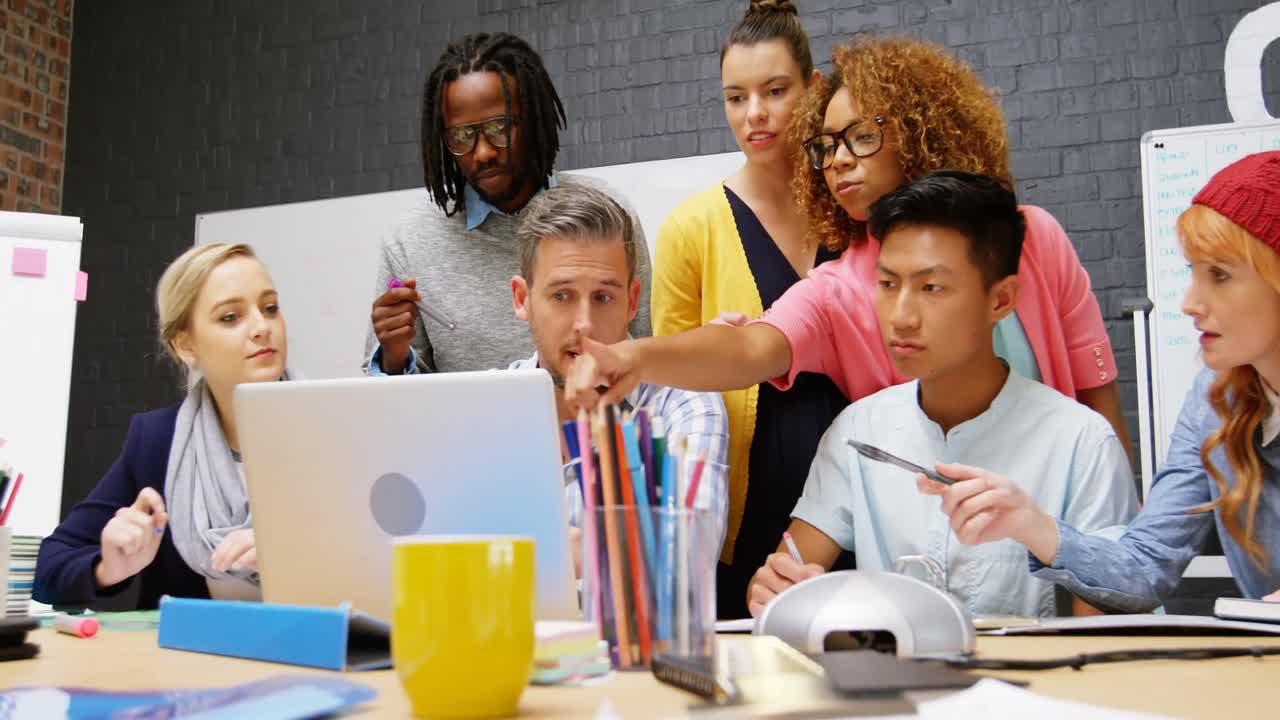 Business executives discussing over laptop in meeting