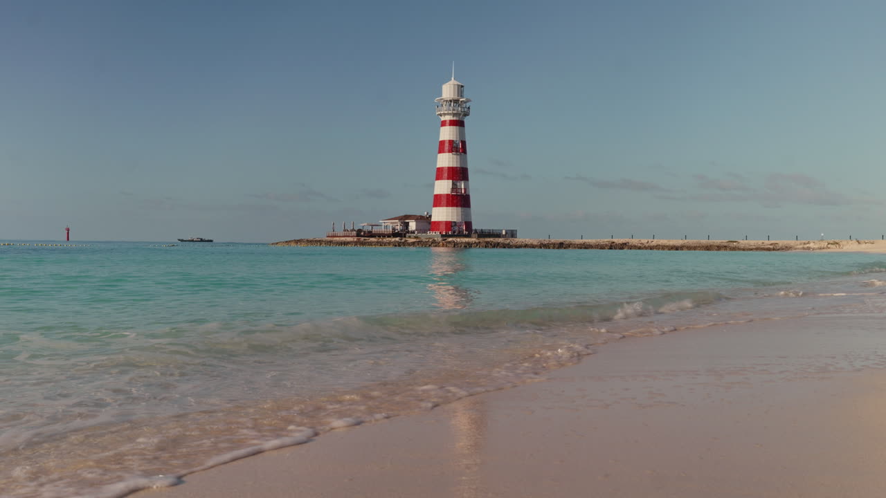 Red and White Striped Lighthouse on a Tropical Beach