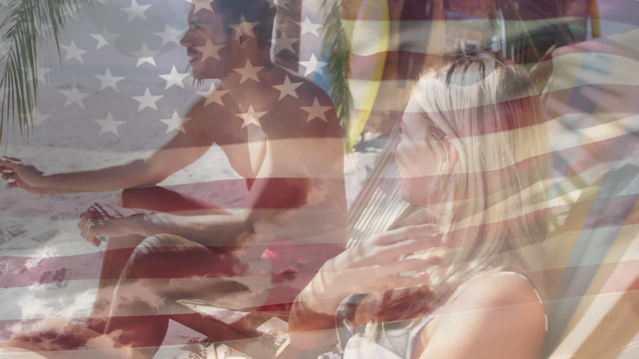bandera estadounidense ondeando contra una pareja caucásica sentada en una silla de cubierta en la playa