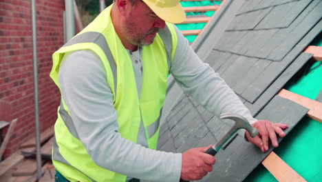 construction worker on building site laying slate tiles