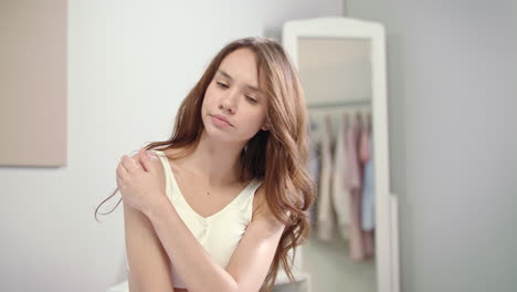 beautiful girl applying medical lotion on illness shoulder. woman body care