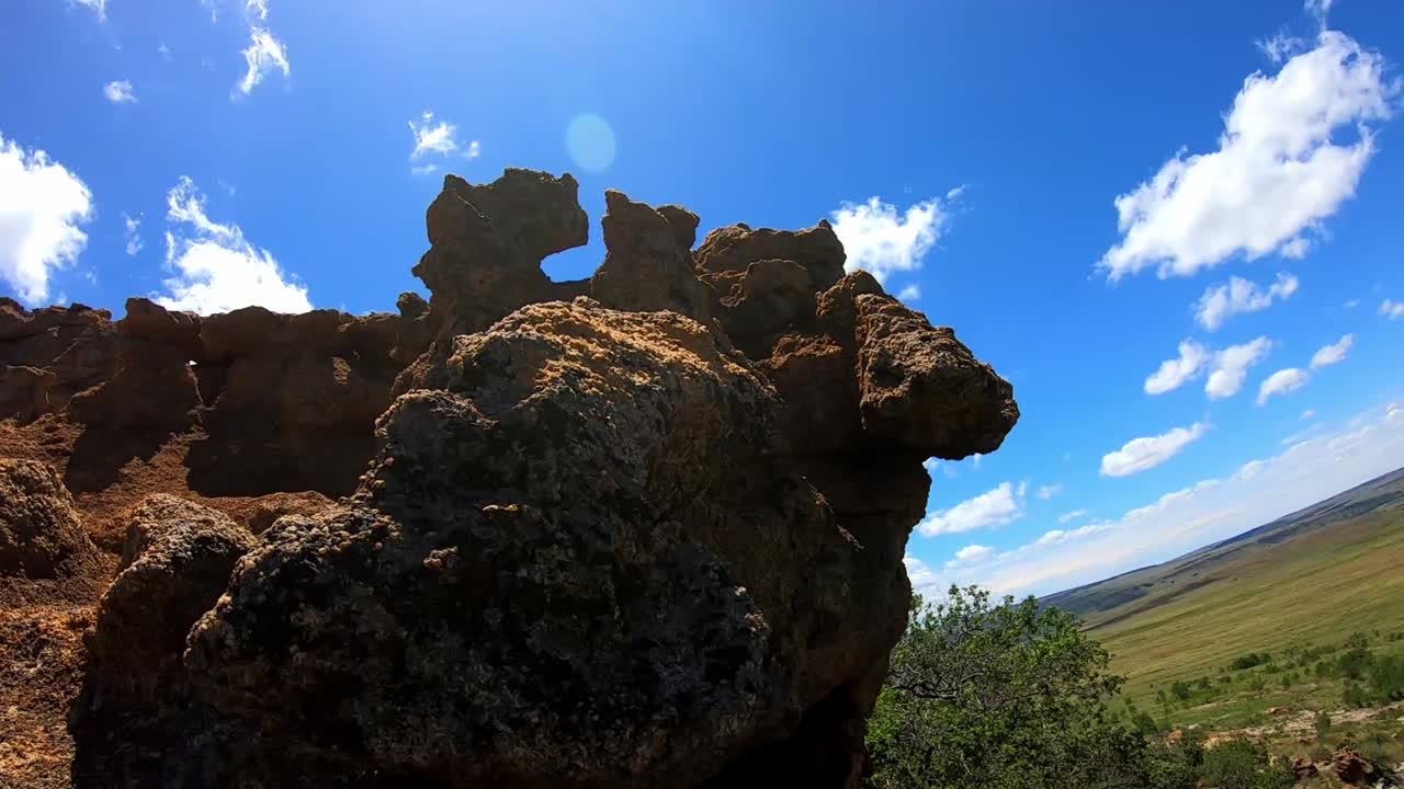 Large Rock formations with blue sky and white clouds.