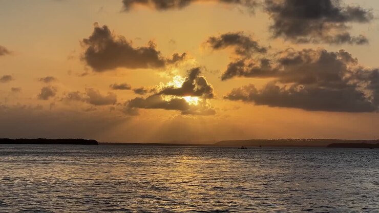 Tilt up landscape shot of a beautiful golden tropical sunset on the Guaraíras Lagoon from the famous tourist destination Tibau do Sul, Brazil near Pipa in Rio Grande do Norte on a summer evening